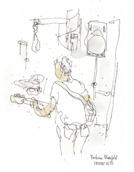 Zeichnung des Gitarristen der Band Fortuna Ehrenfeld bei einem Auftritt. Der Gitarrist von hinten mit Jeans, T-Shirt und der Gitarre um. Gezeichnet mit Fineliner und Aquarell. 