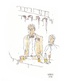 Zeichnung eines Mannes mit beigem Anzug, roter Fliege und rotem Einstecktuch. Er trägt eine Brille. Vor ihm ein Tisch mit gelb-roten Getränken. Hinter ihm eine Frau. Gezeichnet mit Aquarell und Fineliner.