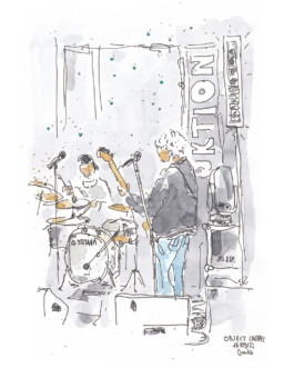 Zeichnung von einer Band auf der Bühne. Mit Fineliner und Aquarell. Ein Band-Mitglied von hinten. Trägt Jeans und eine Gitarre. Zwei Mikrofon-Ständer. Hinten der Schlagzeuger am Schlagzeug. Rechts eine längliche Box. 